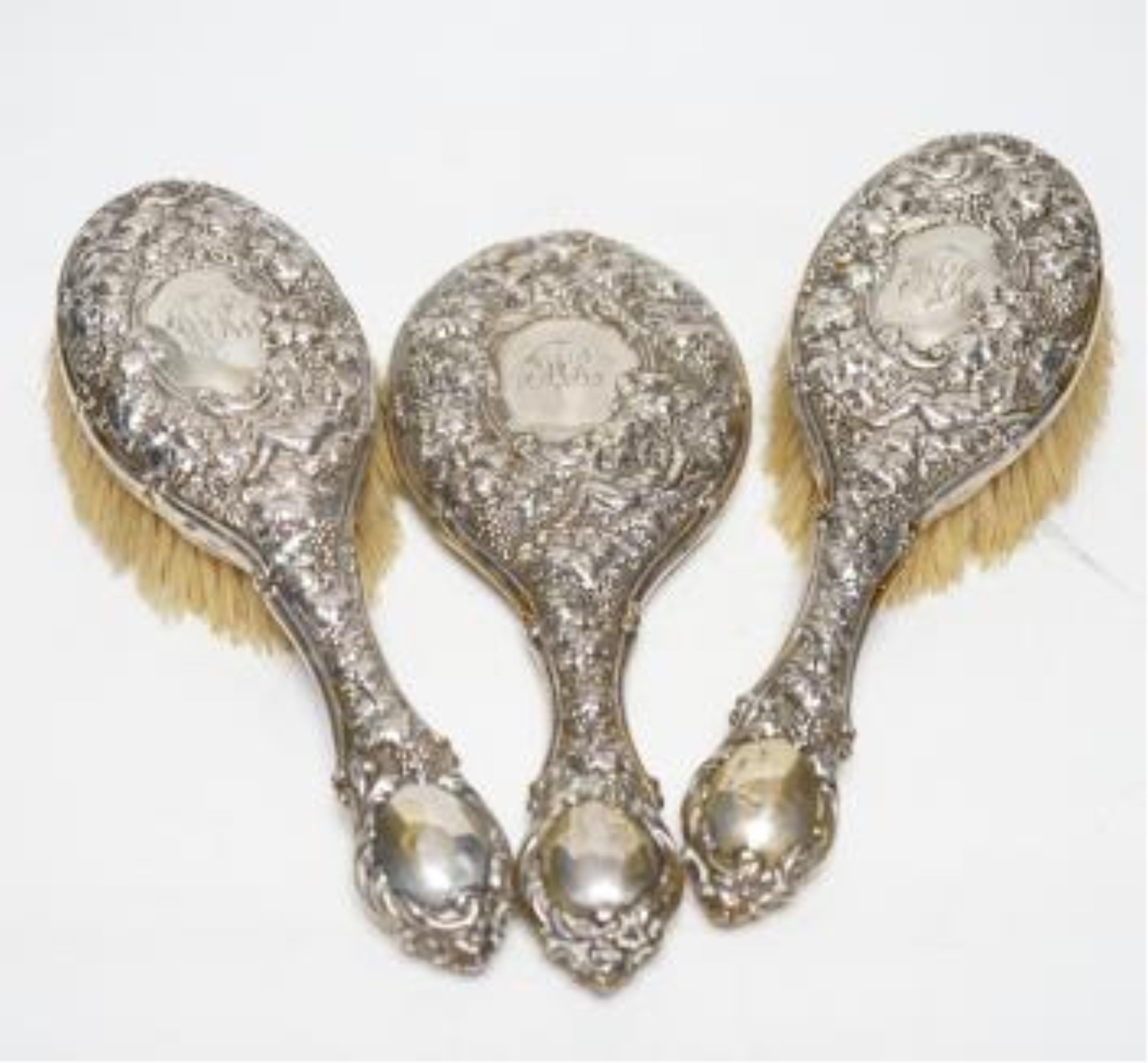 A George V Art Deco silver and enamel mounted ten piece mirror and brush set, Birmingham, 1931, together with an earlier repousse silver mounted six piece mirror and brush set and a cased part manicure set. Poor conditio